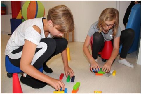 zwei Kinder spielen mit bunten Bauklötzen